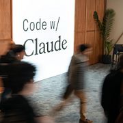 Människor passerar en reklamskylt under Anthropics utvecklarkonferens ”koda med Claude”