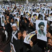 Bilder med Mojtaba Khamenei hålls upp av en folksamling.