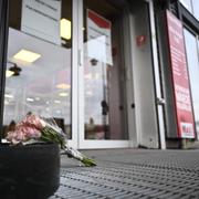 Blommor utanför den butik där en kvinna i 60-årsåldern knivhöggs till döds på tisdagskvällen. 