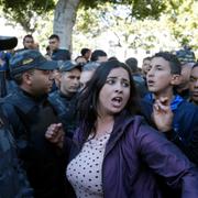 En kvinna protesterar i Tunis den 14 januari. 