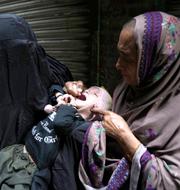 Sjukvårdare som vaccinerar ett barn mot polio.