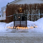 Ljus placerade utanför det hus där en 55-årig kvinna blev mördad och ytterligare två blev skadade på juldagen.
