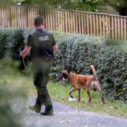 Tysk polis söker igenom en trädgård som en del i utredningen av McCann-fallet.