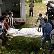Volontärer hanterar en kropp efter  översvämningarna i Nepal.