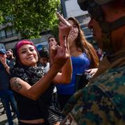 En demonstrant ger en militär fingret i Santiaho.