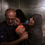 Palestinier på al-Shifasjukhuset i Gaza stad sörjer en anhörig som dödades när hen försökte nå en hjälpsändning som kom med lastbil.