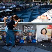 Rebecka Nordin från Moderatera ungdomsförbundet Muf sätter upp valaffischer på Ulf Kristersson vid Sergels torg i Stockholm.