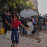 Palestinier hämtar vatten i dunkar vid en distributionsstation den 11 maj.