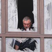 En man ser ut genom ett trasigt fönster i Kyiv efter nattens ryska attacker. 