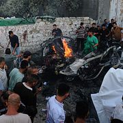 Palestinier samlas runt ett fordon som träffats i ett israeliskt luftangrepp i Gaza stad på söndagen.
