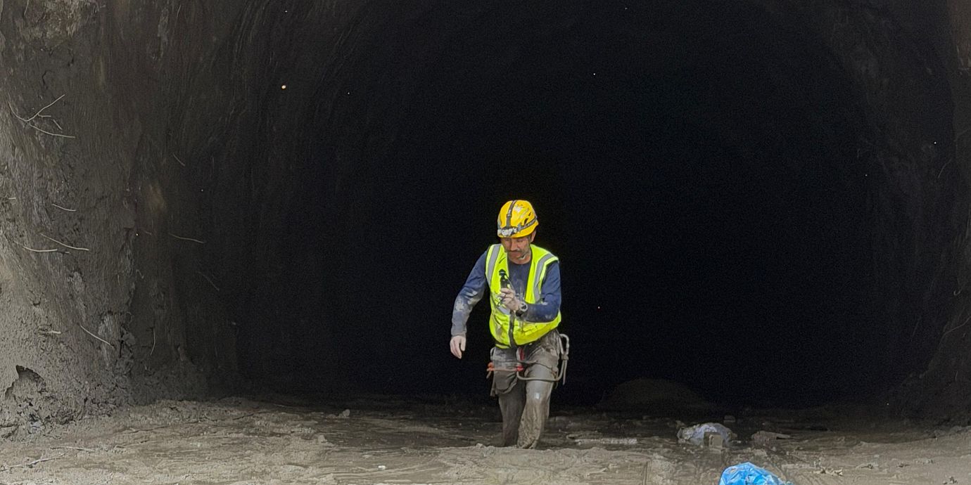 En räddningsarbetare på väg ut ur en vattenkraftstunnel i Nepal.