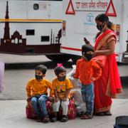 Familj väntar på en bus i New Delhi.