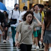 Människor går i de första regnskurarna från stormen Krathon i Taiwan på måndagen. 