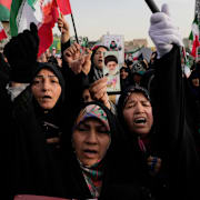 Kvinnor som stöttar den iranska regimen håller upp en bild på ayatolla Ali Khamenei i Teheran i maj förra året.