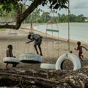 Barn leker vid en bortsköljd strand i Mele, Vanuatu i juli 2025.