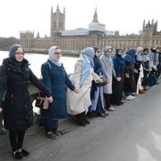 Kvinnor står hand i hand på Westminster bridge i London för att hedra offren i Londonattacken 22 mars.