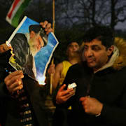 Demonstranter utanför Irans ambassad tänder eld på en bild föreställande ayatolla Ali Khamenei.