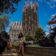 Människor fotograferas framför katedralen Sagrada Familia 2021. 