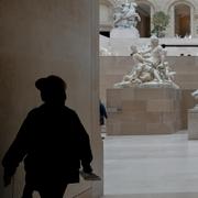 En person går i ett av gallerierna på Louvren. Arkivbild.