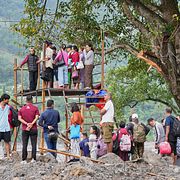 Människor som väntar i kö för att kunna ta sig över en flod i Nepal.