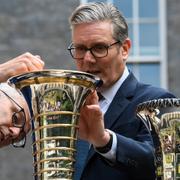 Keir Starmer inspekterar en F1-pokal utanför 10 Downing street i London. 