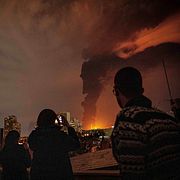 Invånare i Teheran fotograferar den svarta röken som pyr ut från en brinnande oljedepå strax utanför staden, den 7 mars 2026.