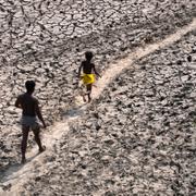 En man och en pojke går längs med en nästintill uttorkad flodbädd i New Delhi, 2 maj. 