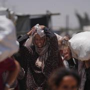 Palestinier bär påsar som innehåller mat och humanitära hjälppaket levererade av Gaza Humanitarian Foundation den 16 juni.