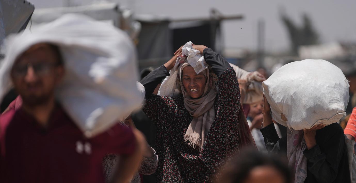 Palestinier bär påsar som innehåller mat och humanitära hjälppaket levererade av Gaza Humanitarian Foundation den 16 juni.