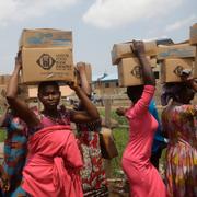 Residents of Oworonshoki Slum carry their food parcels distributed by the Lagos Food Bank Initiative in Lagos, Nigeria, July 10, 2021.