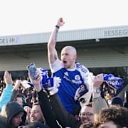 Spelare och supportrar jublar. 