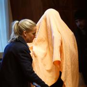 Arkivbild. Mannen under en gul filt i samband med häktningsförhandlingen 2019. 