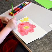 Arkivbild: Barn målar blommor på en förskola. 