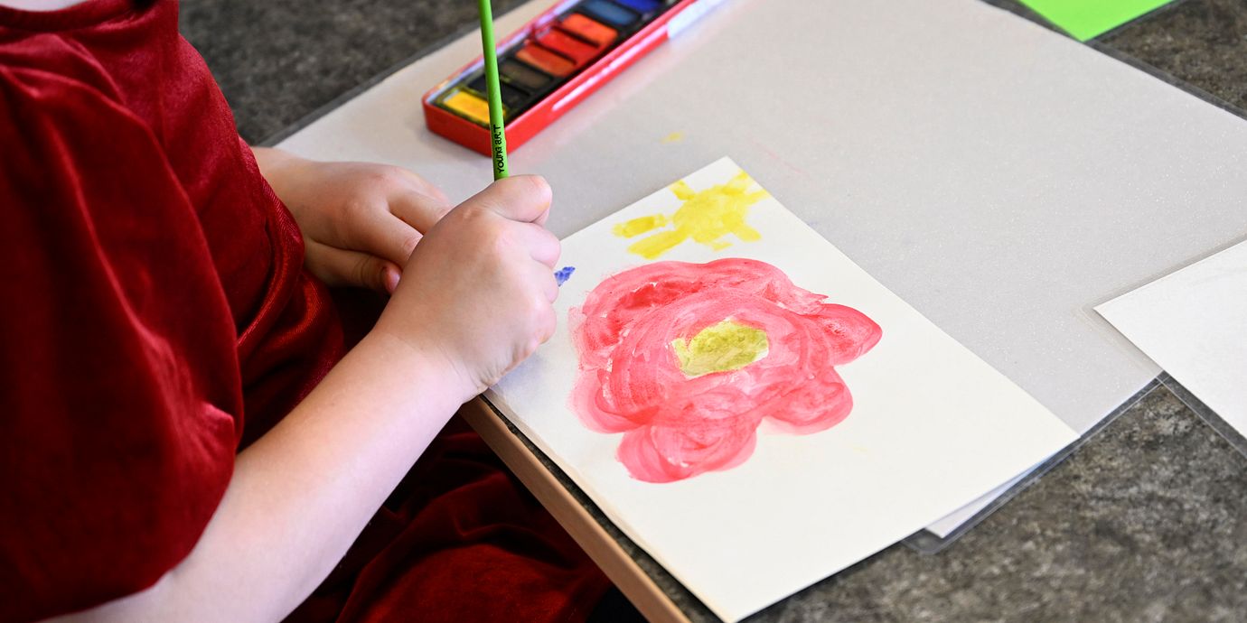Arkivbild: Barn målar blommor på en förskola. 