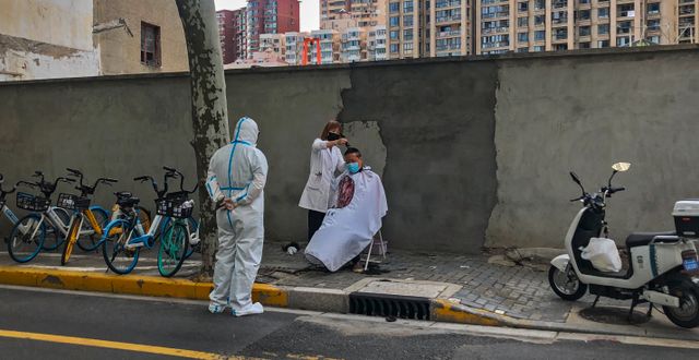 En man klipper sig i Shanghai Chen Si / AP
