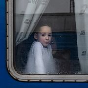 En flicka tittar ut genom ett tågfönster i Lviv den 24 februari 2022, samma dag som Ryssland inledde sin fullskaliga invasion av Ukraina.
