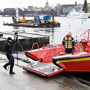 Polisens tekniker och brandpersonal på väg ut i båt mot pontonen där kroppen hittades.