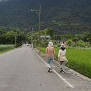 Två kvinnor på promenad i det taiwanesiska landskapet.