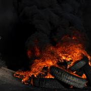 Palestinsk demonstrant och brinnande bildäck i Jenin.