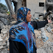 En kvinna står i resterna av sitt hem, som förstördes i en israelisk flygattack under tisdagen.