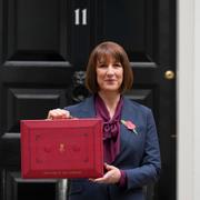 Britain's Chancellor of the Exchequer, Rachel Reeves, holds up the traditional red ministerial box containing her budget speech, as she poses for the media outside No 11 Downing Street, before departing to the House of Commons to deliver the budget in London, Wednesday, Oct. 30, 2024. 