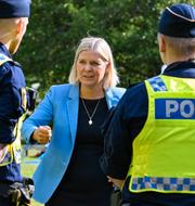 Socialdemokraternas partiledare Magdalena Andersson pratar med poliser i samband med sitt sommartal vid Högbo bruk i Sandviken den 25 augusti.