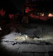 A man walks past a crater at the site of an Israeli airstrike in Beirut's southern suburbs Friday, Sept. 27, 2024. (AP Photo/Bilal Hussein)  BGK119