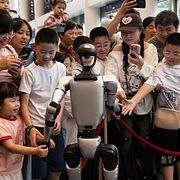 En robot omgiven av barn på World Intelligent Industry Expo 2025 i Chongqing, Kina.