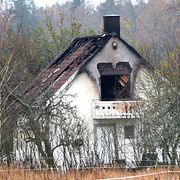 Poliser och avspärrningar vid utbrunnet hus i Åsta utanför Köping på lördagsmorgonen.