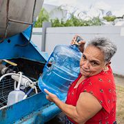 Kvinna fyller vattendunk i Puerto Rico.