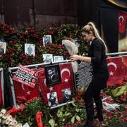 En kvinna lämnar blommor framför nattklubben Reina i Istanbul där 39 människor dödades på nyårsnatten, 17 januari.