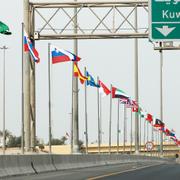 Flaggor för de 70 länder som deltar i konferensen längs en motorväg i Kuwait city.