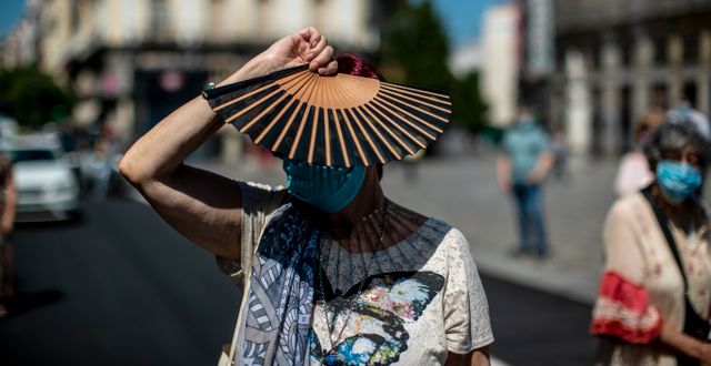 En kvinna med munskydd deltar i en tyst minut för pandemins offer i centrala Madrid. Manu Fernandez / TT NYHETSBYRÅN