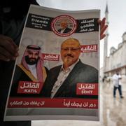 En man håller i en bild av Jamal Khashoggi och den saudiske kronprinsen Muhammed bin Salman, där de beskrivs som ”martyr” repsektive ”mördare”, i Turkiet. Arkivbild.